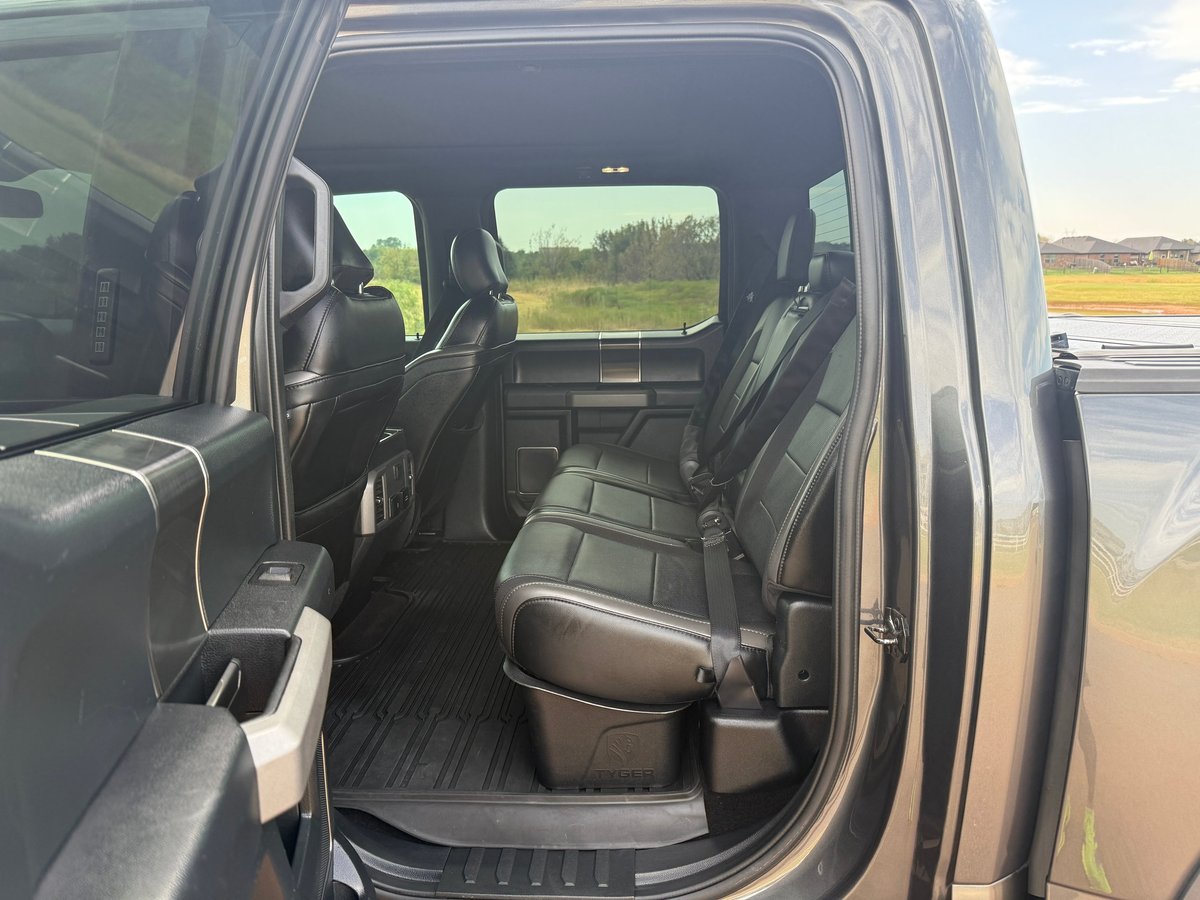 Truck rear cab with black leather seats viewed from open rear door in a parking lot